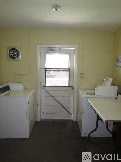 A room with a white desk and a white cabinet.