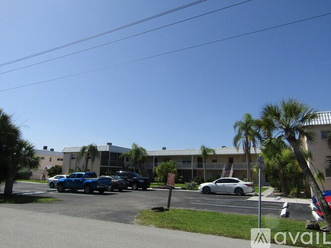 A parking lot with cars and a building in the background.