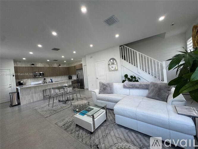 A modern living room with a white sofa and a wooden bar area.