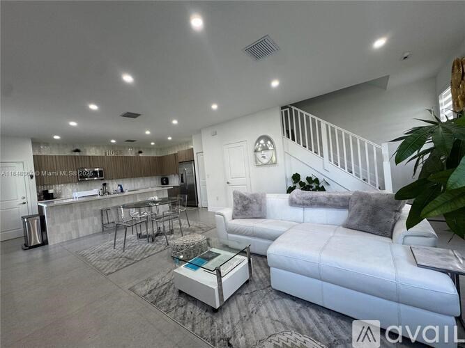 A modern living room with a white sofa and a wooden bar area.