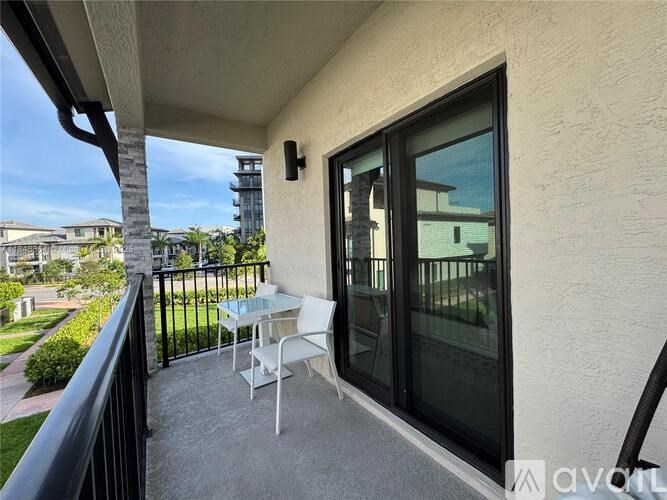 A patio with a table and chairs overlooks a green lawn.