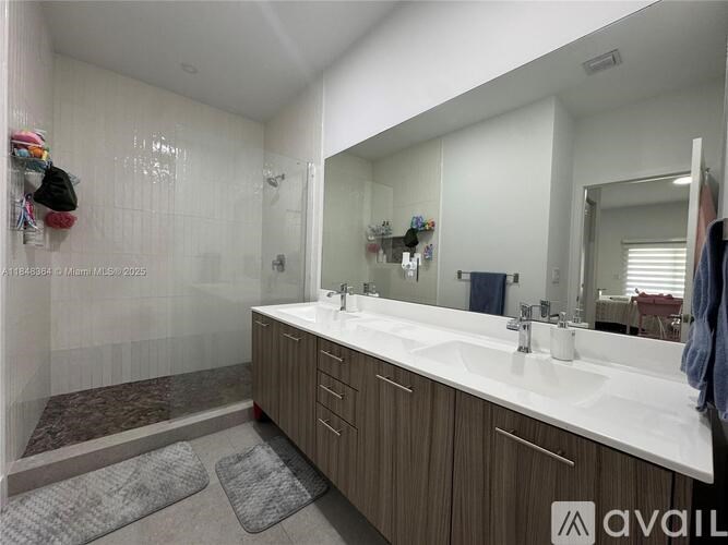 A bathroom with a white countertop and a mirror above it.