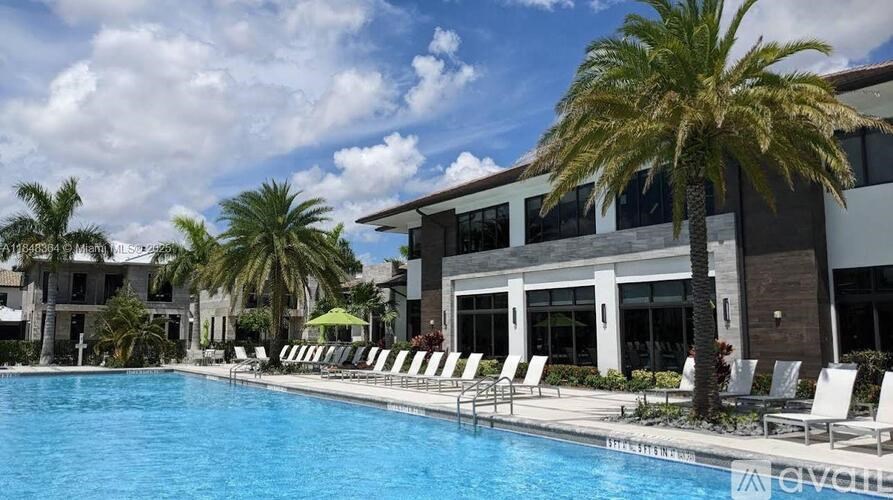A pool with chairs and a building in the background.