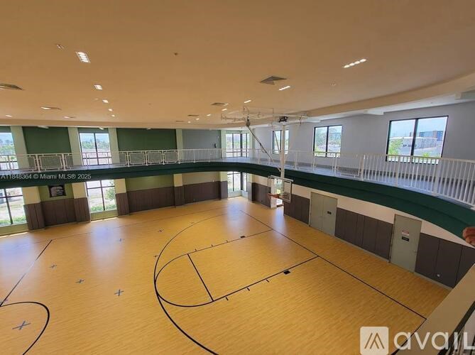 A large indoor basketball court with wooden flooring and a high ceiling.