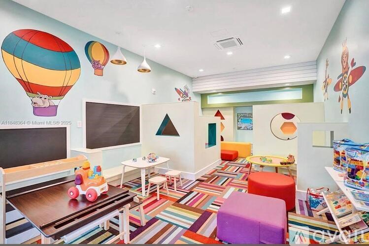 A room with a hot air balloon on the wall and a table with a toy car on it.