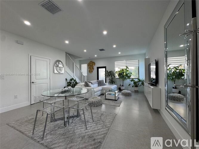 A modern living room with a glass table and chairs.