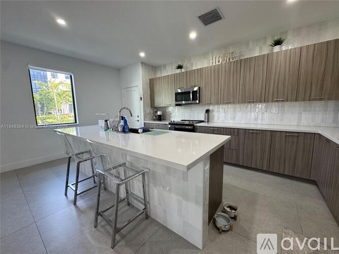A modern kitchen with a white countertop and a window.