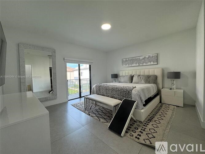 A bedroom with a large bed, a mirror, and a bench.