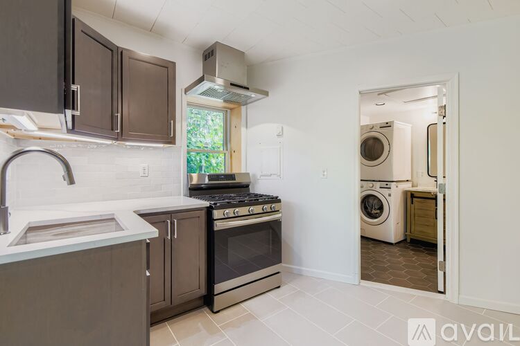 A kitchen with dark brown cabinets and a stainless steel stove.