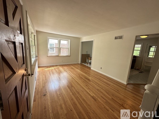 A room with wooden flooring and a large window.