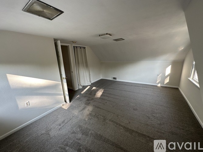 A room with carpeted floor and a doorway leading to another room.