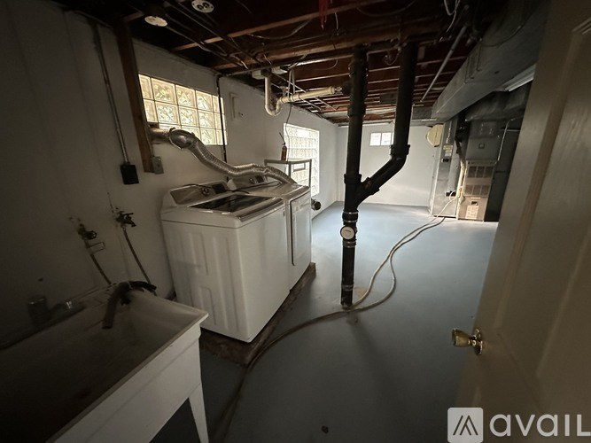 A bathroom with a white sink and a white bathtub with a window above it.