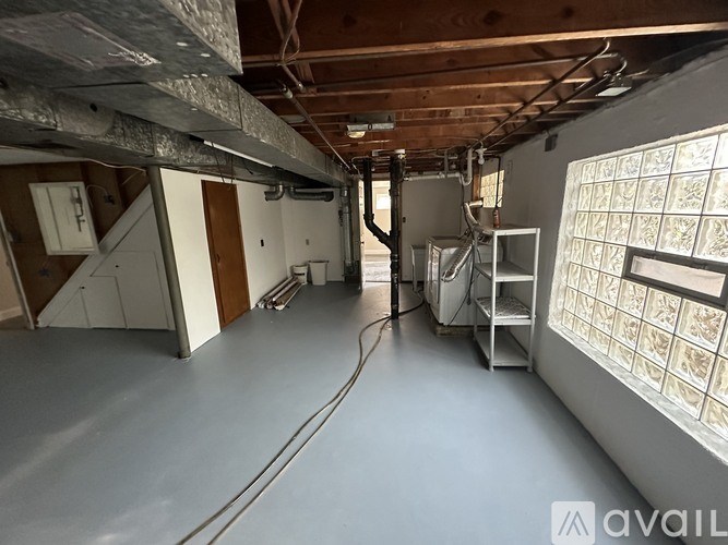 A large, empty room with a concrete floor and a window on the right side.