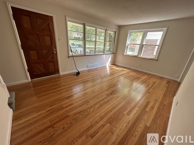 A room with wooden flooring and a brown door.