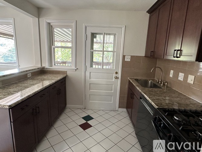 A kitchen with brown cabinets and a white door.