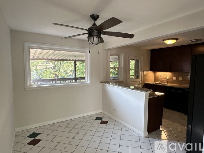 A room with a ceiling fan and a window with blinds.