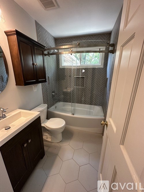 A bathroom with a glass shower door and a white toilet.