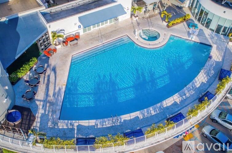 A large outdoor swimming pool surrounded by a white fence.