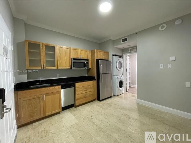 A kitchen with wooden cabinets and a black countertop.