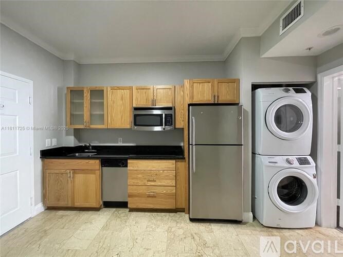A kitchen with wooden cabinets and a black countertop.
