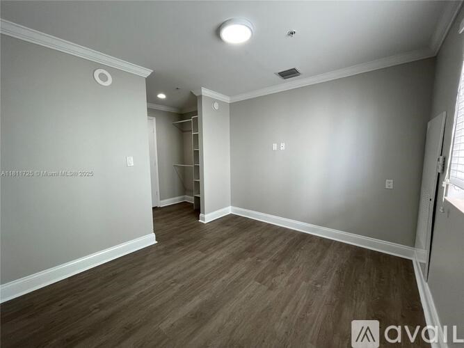 A room with wood flooring and white walls.
