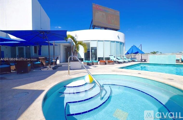 A pool with a slide and a building in the background.