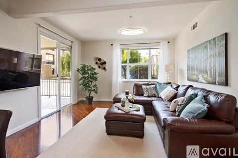 A living room with a brown leather couch and a flat screen TV.