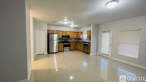 A kitchen with white cabinets and a white refrigerator.
