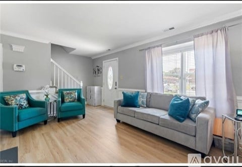 A living room with a grey couch and a green armchair.