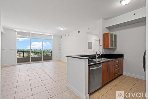 A kitchen with white cabinets and a black countertop is available for rent.