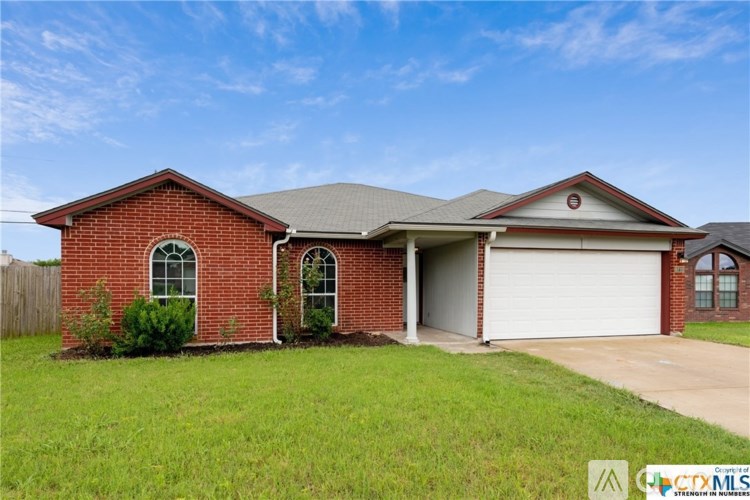 A red brick house with a white garage door.