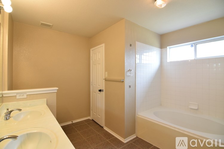 A spacious kitchen and living room with white cabinetry and a tiled floor.