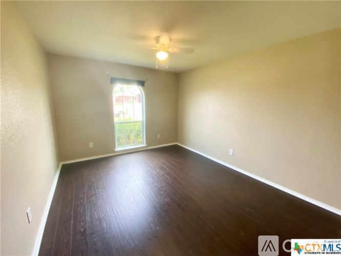 Empty room with wooden floor and a window.