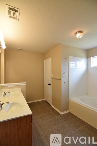 A bathroom with a sink, mirror, and bathtub.