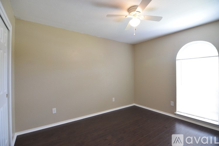 A room with a ceiling fan and a window.