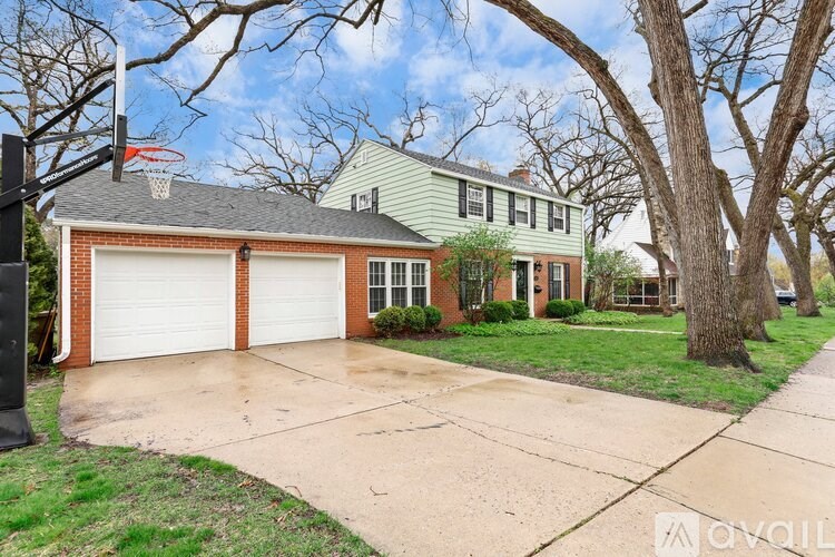 A house with a basketball hoop in the front yard.