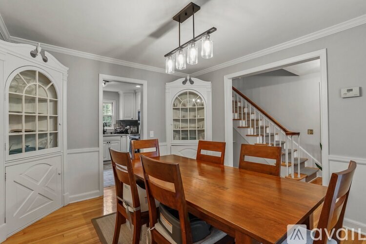 A dining room with a wooden table and chairs.