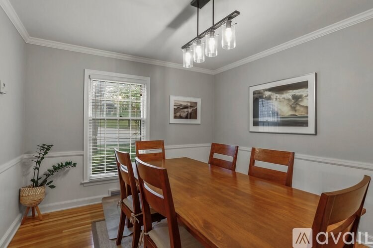 A dining room with a wooden table and chairs.
