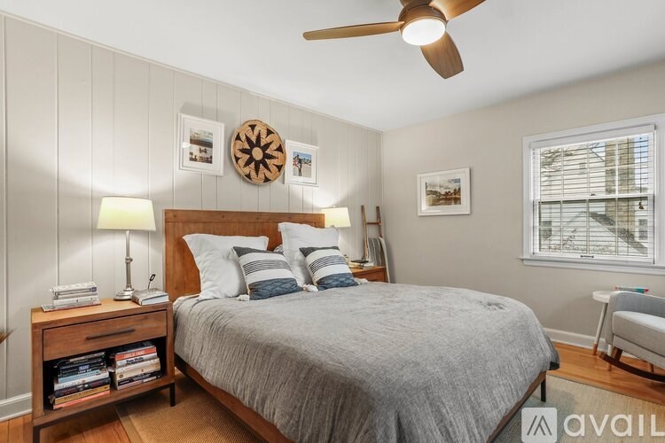 A bedroom with a bed, a ceiling fan, and a window with blinds.