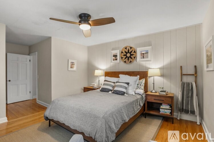 A bedroom with a bed, nightstand, and a ceiling fan.