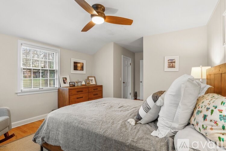 A bedroom with a bed, dresser, and window.
