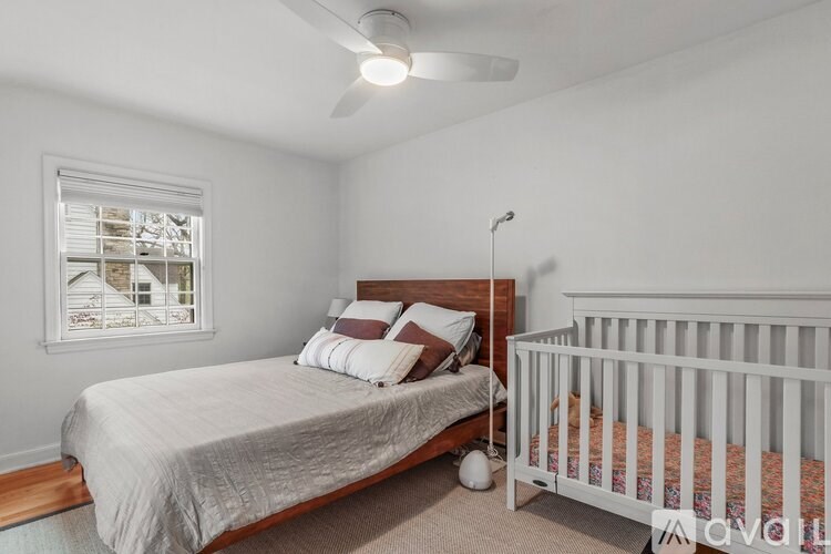 A bedroom with a bed and a crib.