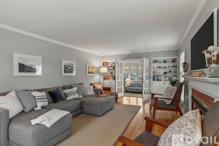A living room with a grey couch and a fireplace.