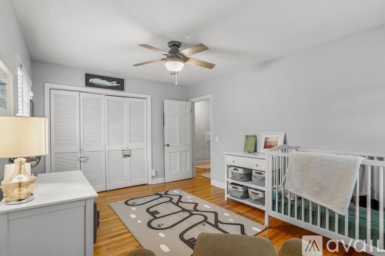 A baby room with a crib and a fan.