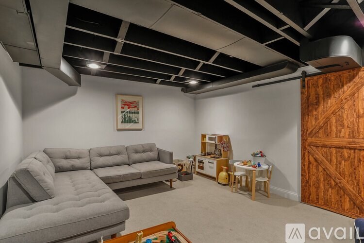 A living room with a grey sofa and a wooden door.