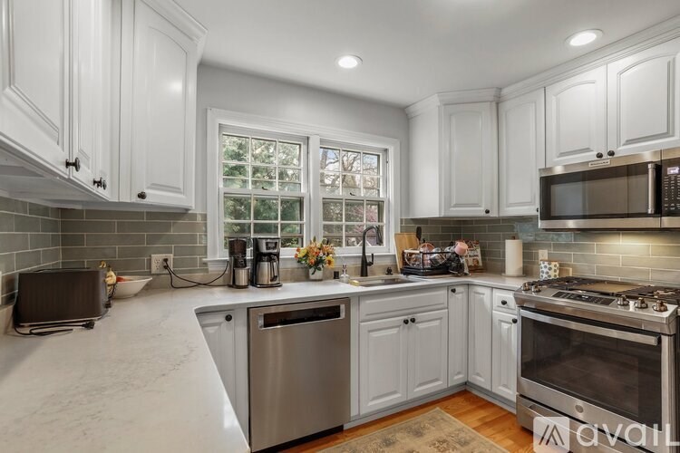A kitchen with white cabinets and stainless steel appliances.