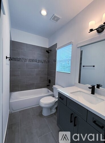 A modern bathroom with a white toilet and a white bathtub.