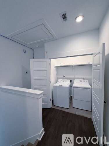 A laundry room with two washing machines and a dryer.