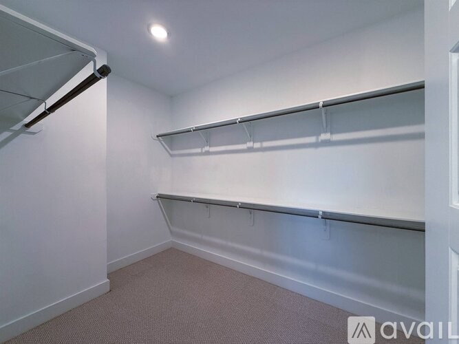 A white wall with a grey shelf and a light on.