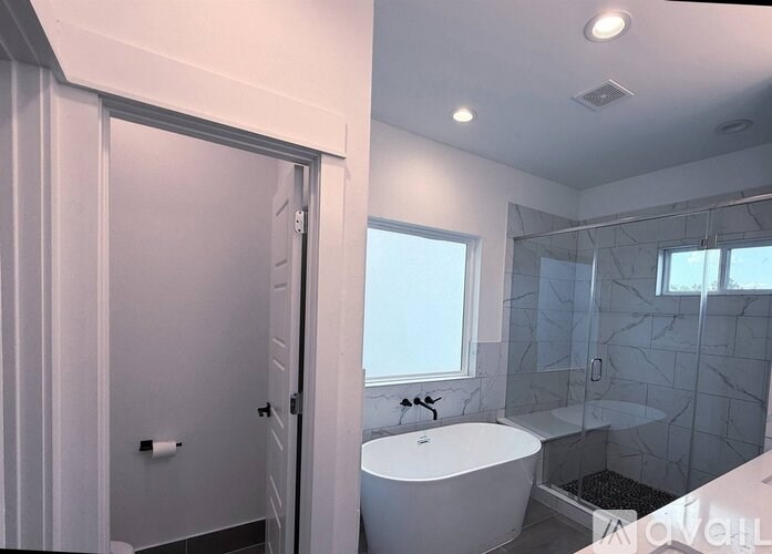 A white bathroom with a tub and shower.
